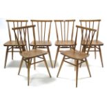A SET OF SIX ERCOL LIGHT ELM WINDSOR SPINDLE-BACK DINING CHAIRS with hard seats & on round tapered