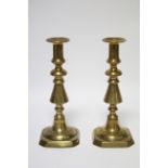 A pair of late 19th/early 20th century brass candlesticks, on turned tapering columns & square