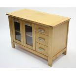 A maple-finish dwarf side cabinet, fitted centre shelf to the left-hand side & centre enclosed by