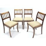 A set of Regency-style mahogany rail-back dining chairs with padded drop-in seats & on sabre legs.