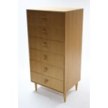 A teak upright chest fitted six long drawers with turned knob handles &on short round tapered