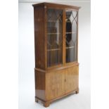 A George III-style yew wood tall standing bow-front bookcase with three adjustable shelves