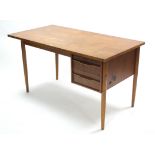 A teak knee-hole desk fitted two long drawers to the right-hand side, and on round tapered legs,