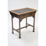 An Edwardian oak small writing table inset tooled leather to the rectangular top, fitted frieze