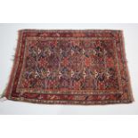 A Persian pattern rug of crimson & ivory ground & with all-over repeating multi-coloured geometric
