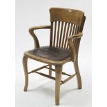 An Edwardian oak lath-back office elbow chair with padded seat, & on cabriole legs with turned