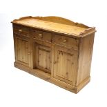 A pine tray-top low sideboard, fitted three frieze drawers above cupboard enclosed by three