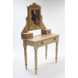 A pine dressing table with rectangular swing mirror to the stage back, fitted frieze drawer & on