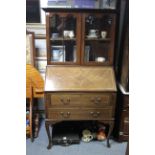 An Edwardian inlaid-mahogany small bureau bookcase, the upper part fitted centre shelf enclosed by