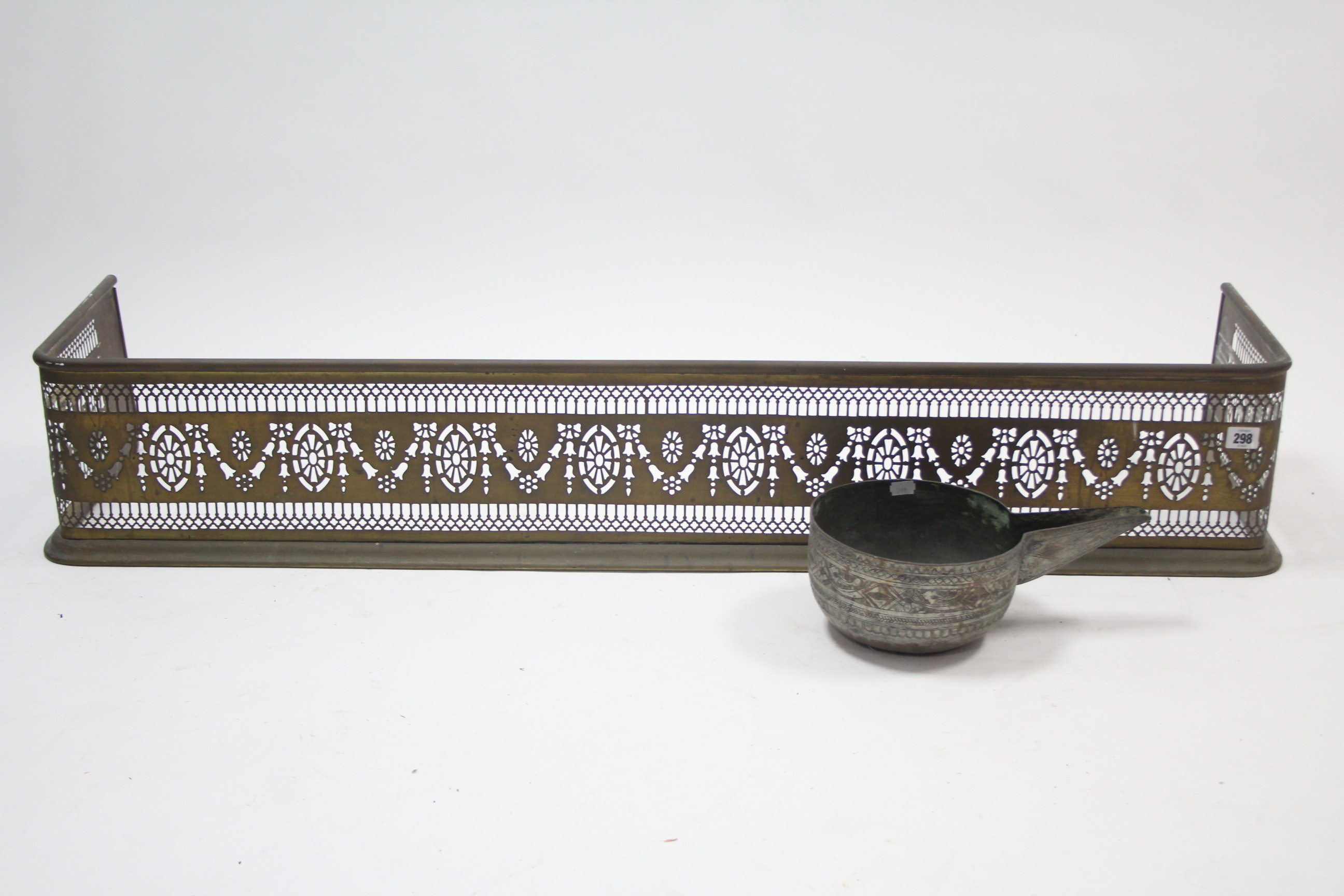 A 19th century brass fender with pierced frieze, 49” long, & an eastern engraved silvered-metal