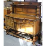 A mid-20th century oak break-front sideboard inset fielded panels to the low-stage panel back, the