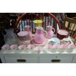 A pink glazed twenty-nine piece part tea service; a similar set of three graduated jugs; a Doulton