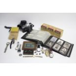 A Nixie small folding camera; an Asahi Pentax “Spotmatic F” camera; five boxes of lantern slides;
