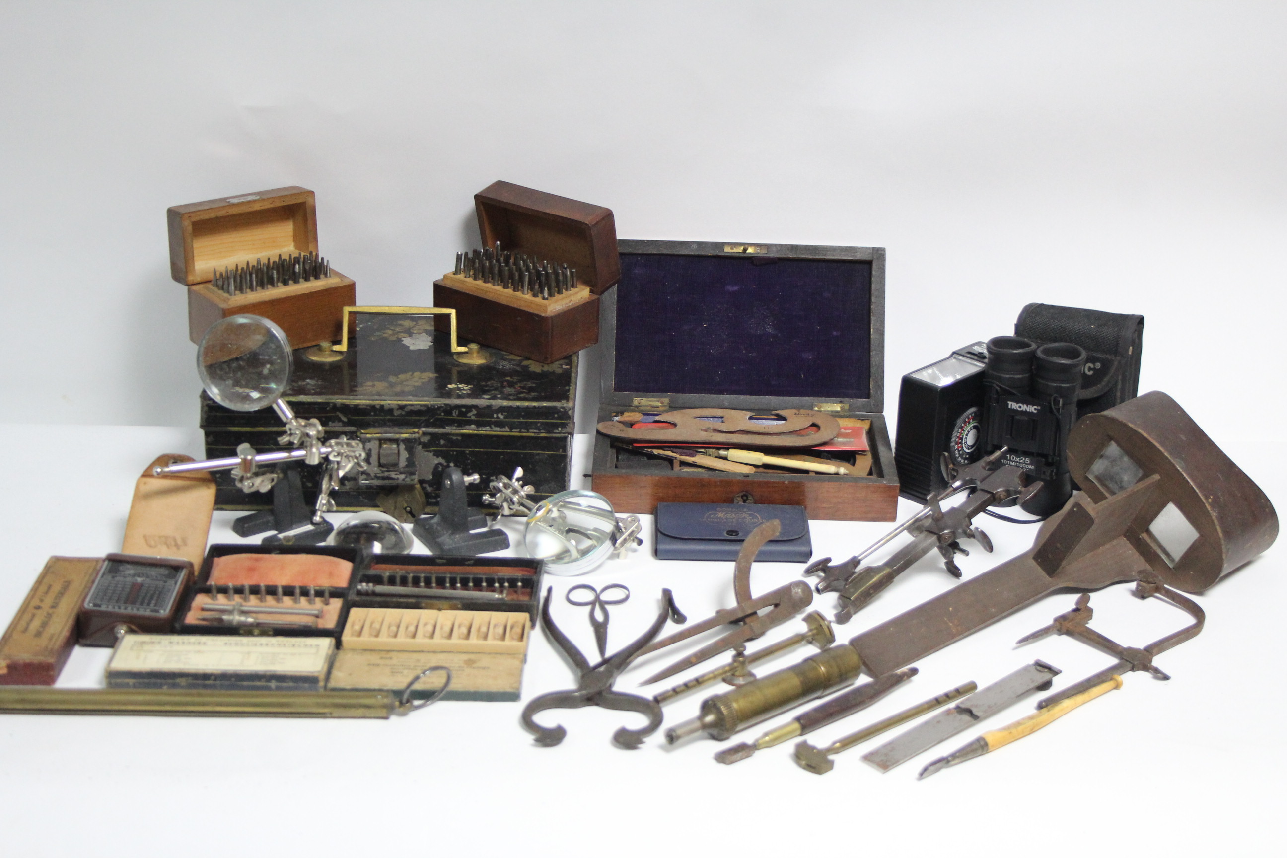 A stereoscope hand-held card viewer; various drawing instruments; a pair of Tronic field glasses,