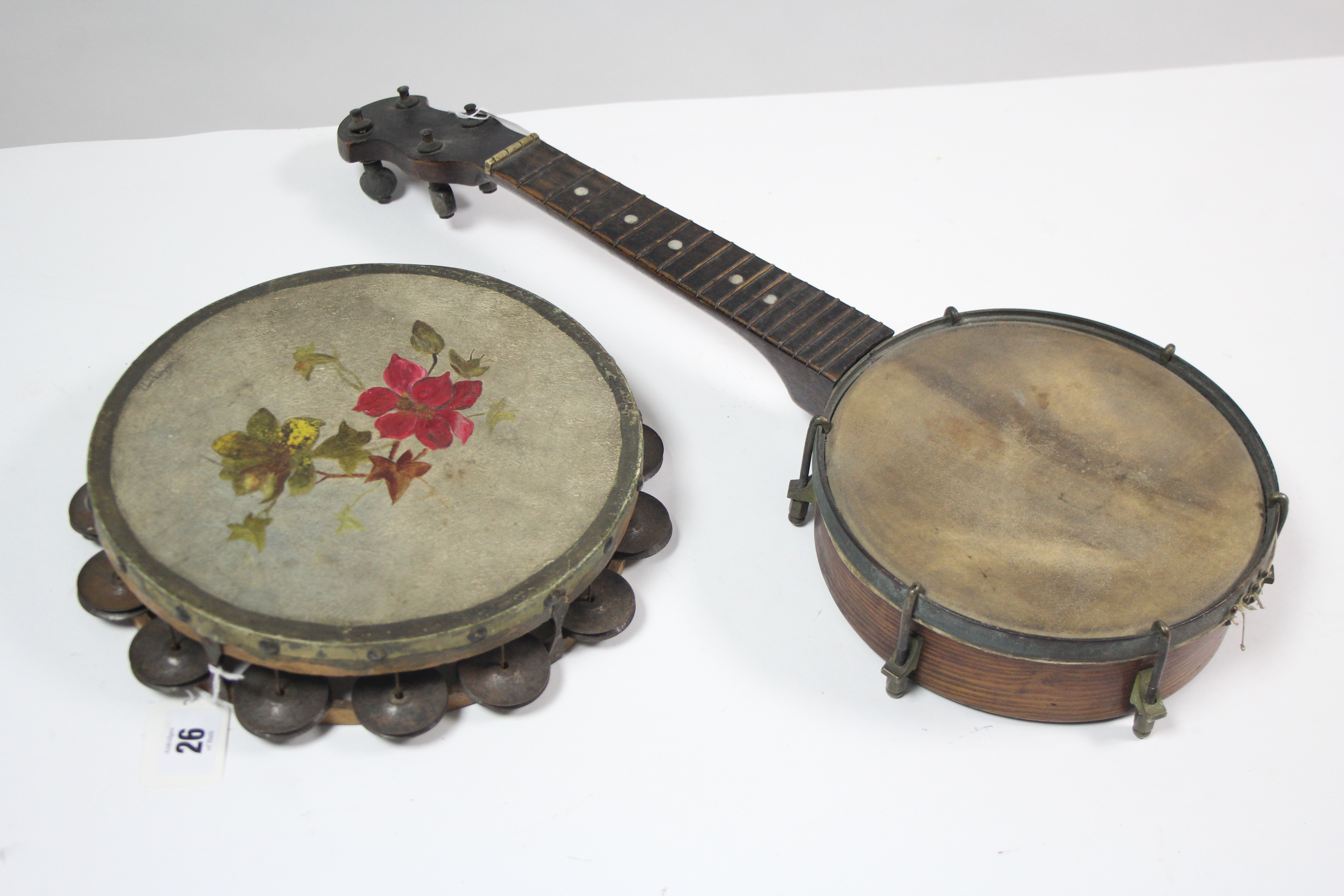 A banjolele (lacking strings), 21" long; & a tambourine with painted floral decoration.
