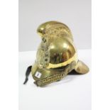 A BRASS FIREMAN'S HELMET WITH LEATHER CHIN STRAP.