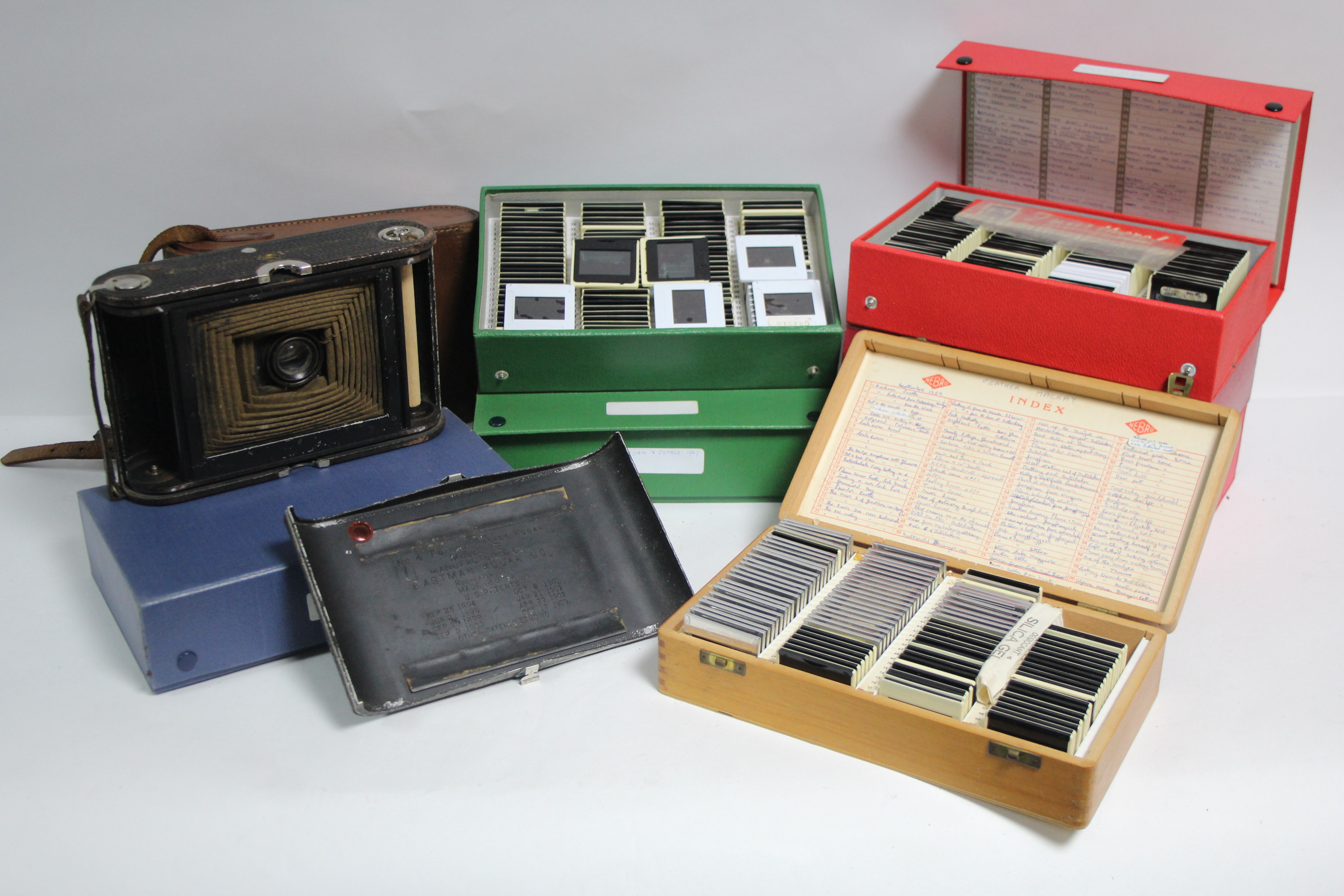 A Kodak “No 4 Folding Pocket” camera with leather case; & various projector slides.