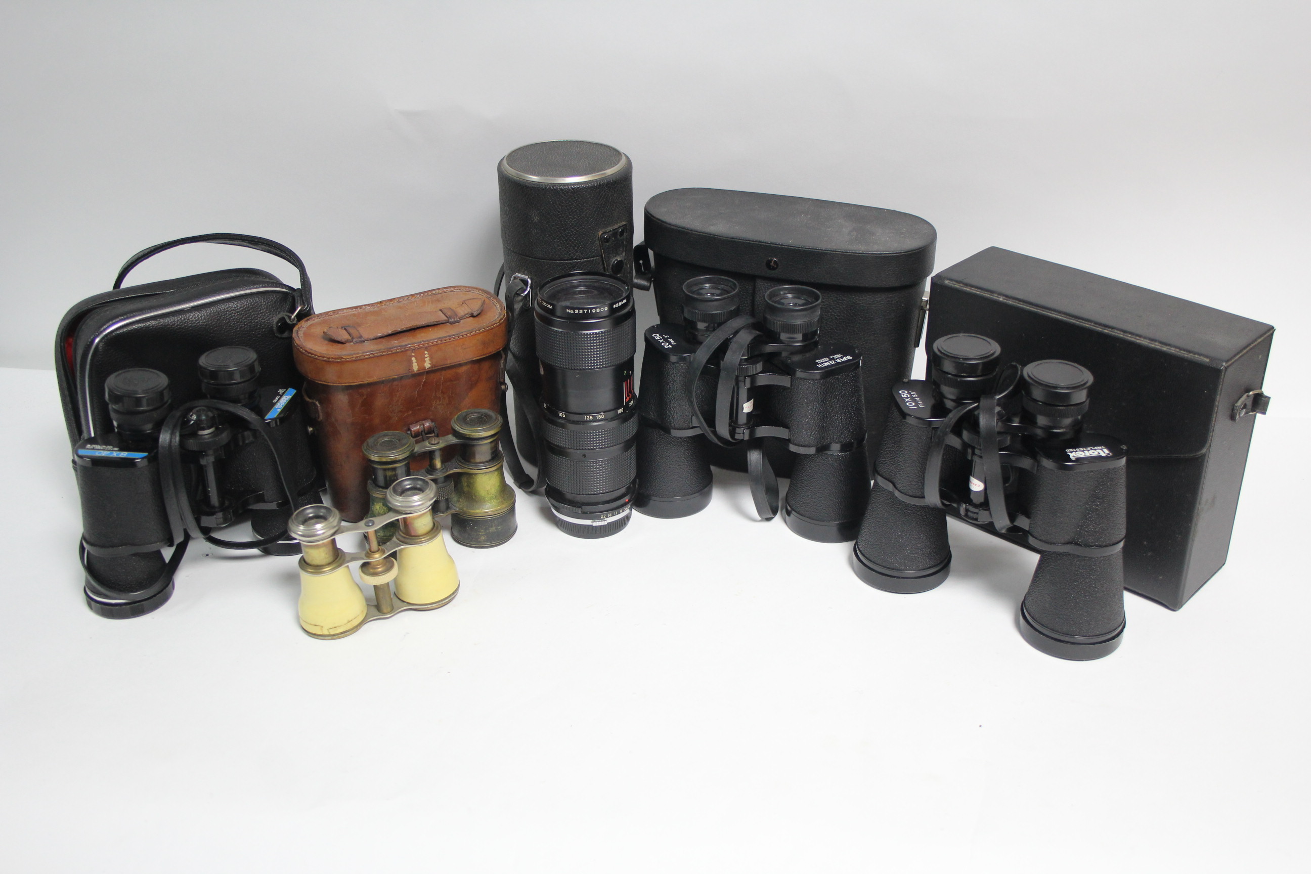 A Vivitar zoom lens; three pairs of binoculars; a pair of field glasses; & a pair of opera glasses.