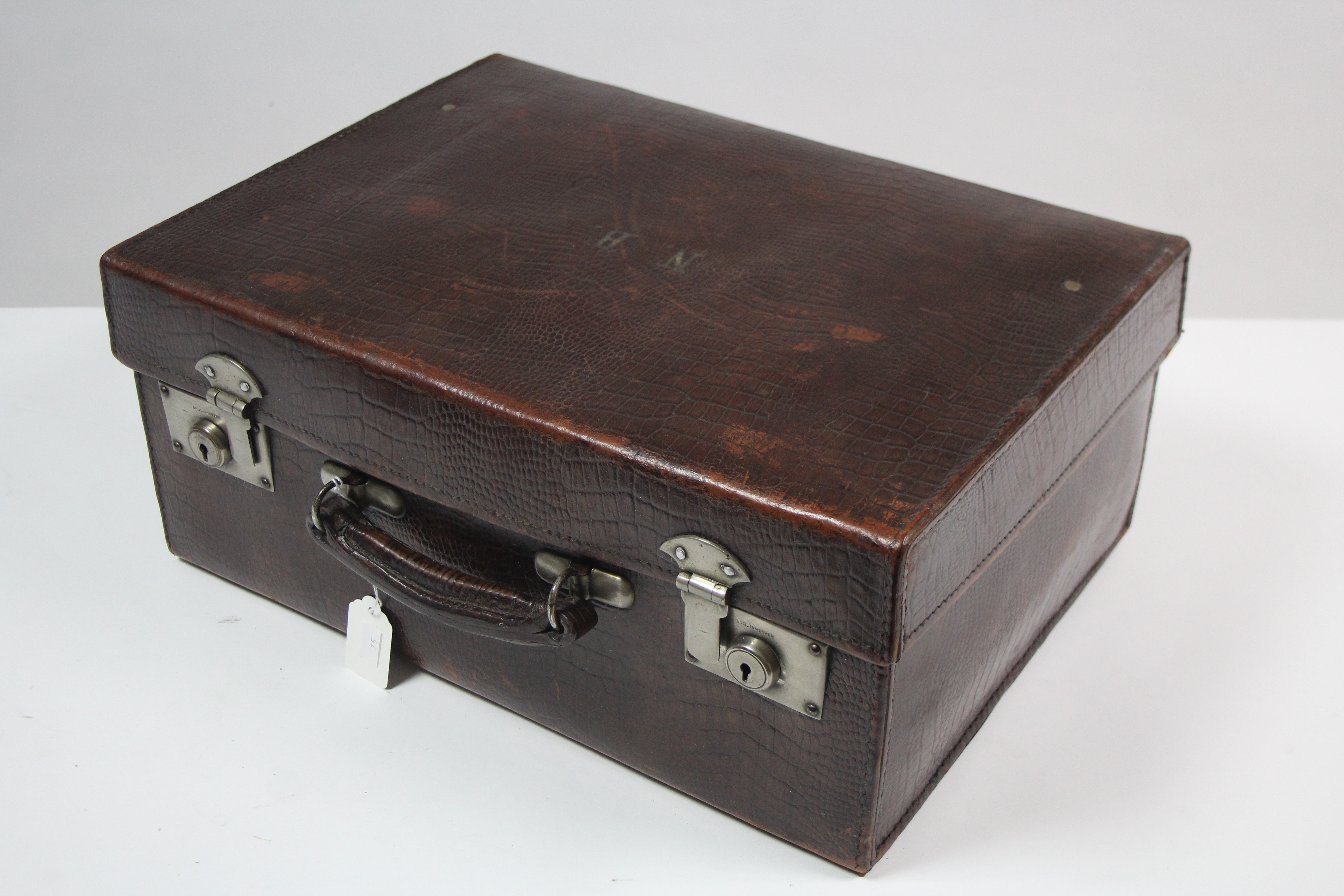 An early 20th century simulated crocodile skin leather travelling case with chrome twin-lever locks,