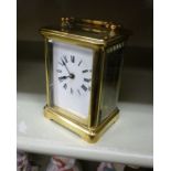 A mid 20thC lacquered brass cased carriage timepiece with a folding top handle and bevelled glass