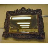 A late 19thC Cantonese mirror, the bevelled plate set in a wide, profusely carved boxwood frame,