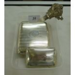 A silver folding cheroot case of curved form with engine turned ornament,