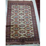 A Bokhara rug with oval and diamond shaped guls on a red ground 74'' x 48'' S