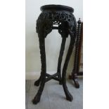 An early 20thC Oriental, profusely carved jardiniere stand with an inset marble top,