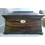 A mid 19thC Coromandel veneered sarcophagus shaped tea casket (with provision for flank ring