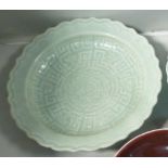 A late 19th/20thC Chinese celadon glazed shallow bowl with a wavy edge,