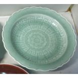 A late 19th/20thC Chinese celadon glazed shallow bowl with a wavy edge,