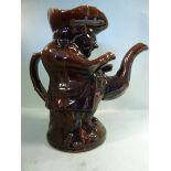 A 19thC Staffordshire treacle glazed pottery Toby jug with a teapot spout 10''h