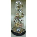 A late Victorian mantel centrepiece, featuring a ceramic bead work and wool floral display,