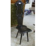 An early 20thC dark stained and carved oak spinning chair with a lyre shaped plank back and solid