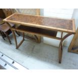 A Richard Williams burr walnut and elm hall table, having a panelled top and undertier,