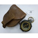 An early 20thC lacquered steel and brass cased pocket compass,