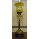 A late Victorian oil lamp with a double burner, a clear glass reservoir, on a reeded brass stem,