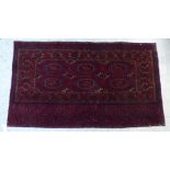 A Tekke Bokhara rug with three columns of guls on a red ground 58'' x 34''