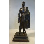 A 19thC patinated cast iron figure, a standing gentleman wearing a tunic,