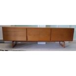 A 1960s Danish teak sideboard, the three doors flanked by four drawers with figure moulded edges,