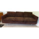 A 1960s three person settee with a low, level back and straight arms,