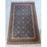 A West Persian rug with repeated geometric motifs on a blue ground 86'' x 53''