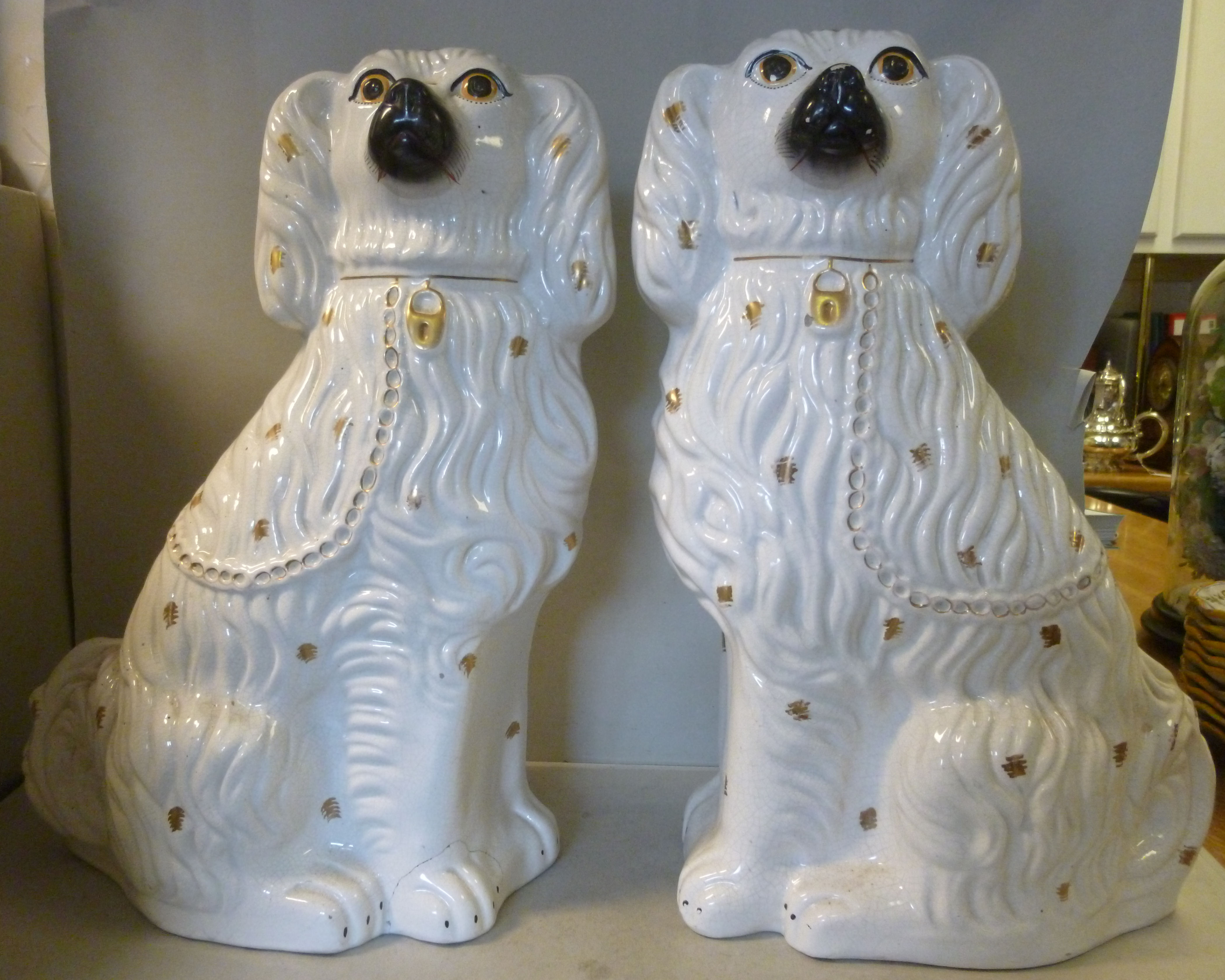 A pair of late Victorian Staffordshire ivory glazed pottery seated King Charles Spaniels with