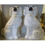 A pair of late Victorian Staffordshire ivory glazed pottery seated King Charles Spaniels with