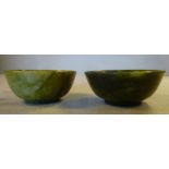 A pair of late 19th/early 20thC Chinese, dark green, turned jadeite bowls, on shallow footrims 2.