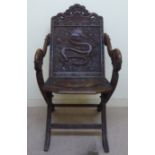 A late 19thC Burmese profusely carved, folding hardwood chair with a panelled back,