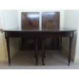 A George III mahogany dining table, the top with a reeded edge, over a stepped frieze,
