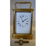 A mid 20thC lacquered brass cased carriage clock with bevelled glass panels and a folding top