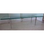 A 1960s coffee table with a clear plate glass top,