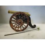 A mid/late 19thC black and red painted cast iron model cannon, on a two,